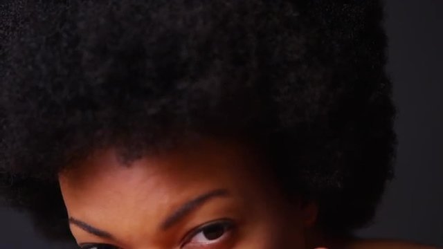 Slow motion close up of African American woman with afro looking at camera
