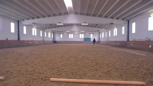 Black Robe Person Galloping Black Horse In Riding Hall