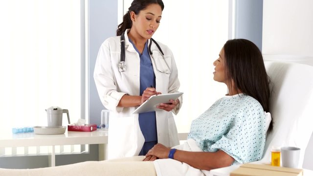 Hispanic female doctor talking to African patient