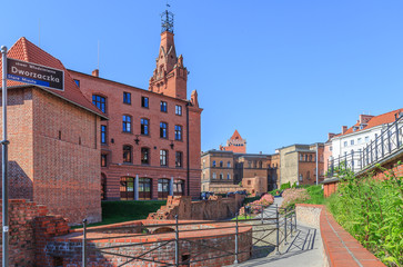 Poznań, stare miasto - fragment odrestaurowanych murów miejskich oraz budynek komendy straży pozarnej z wieżą obserwacyjną przy skwerze Dworzaczka