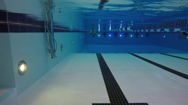 An underwater shot man swimming breastroke laps at pool