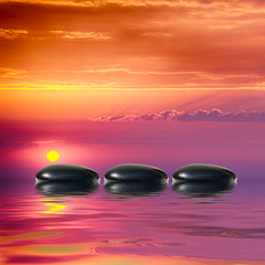 Fototapeta na wymiar Zen spa concept background-Zen black massage stones reflected in water