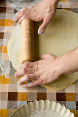Cooking and home concept - close up of male hands kneading dough