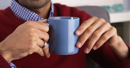 Closeup on a Mexican man's hands holding mug