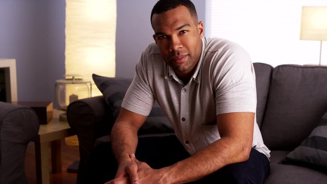 Sexy black man sitting on couch