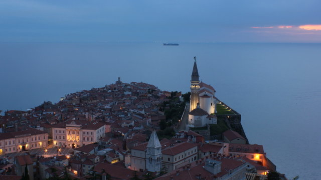 Dawn in to night in Piran with ships traveling timelapse