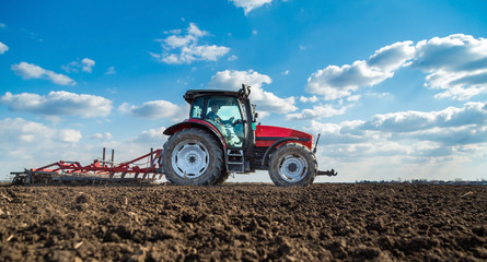 Farmer in tractor preparing land with seedbed cultivator
