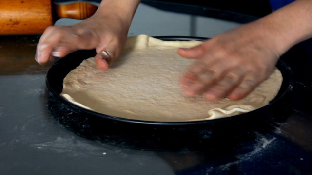 Placing dough in to baking tray close up