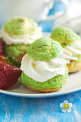 Profiteroles with strawberry compote and whipped cream.