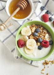 Homemade granola with yogurt, berry and honey