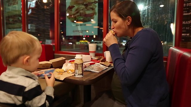 a pregnant mother and toddler eating fast food