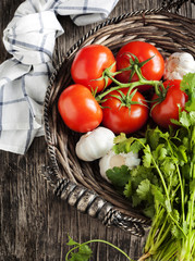 Fresh Tomatoes, garlic and cilantro in Basket.