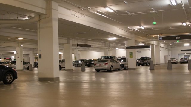 People and cars in empty parking garage