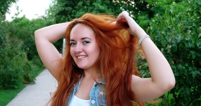 Portrait of a beautiful redhead girl in the spring garden happy