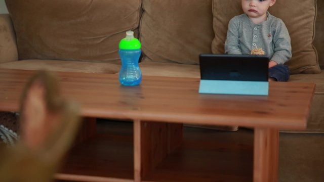 cute toddler boy watching a show on a tablet