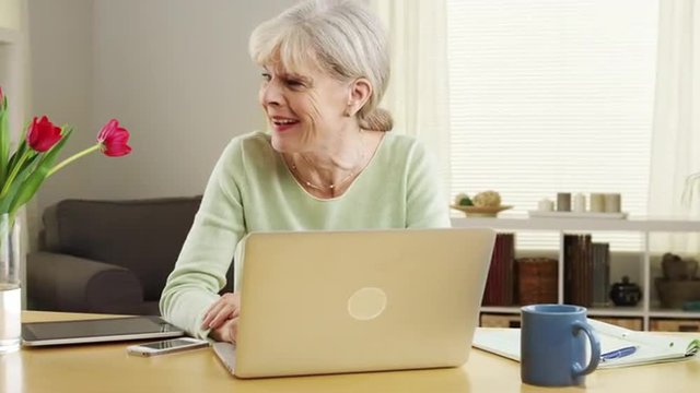 Happy laughing mature woman laptop computer