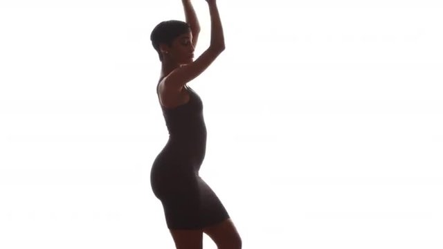 Woman in tight black dress dancing on white background