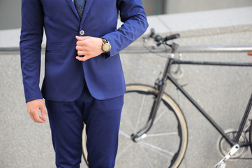 Well-dressed man  standing near bicycle