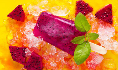 Homemade frozen popsicles made with Dragon fruit on ice background