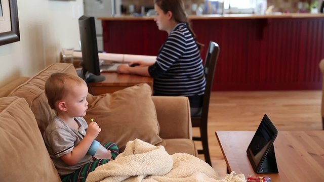 pregnant mother in home office with toddler