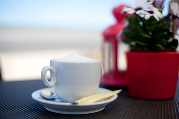 Cup of coffee on the balcony in front of the sea