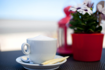 Cup of coffee on the balcony in front of the sea