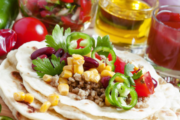 Cooking burritos, tortilla filling on the open, selective focus
