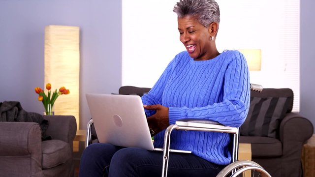 Mature African woman talking with friend on laptop