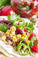 Cooking burritos, tortilla filling on the open, selective focus