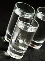 Three glasses of vodka, black and white, selective focus