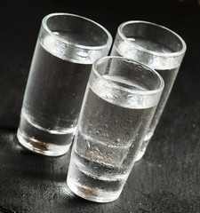 Three glasses of vodka, black and white, selective focus