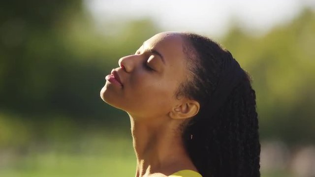 Black woman feeling the sun shine on her face
