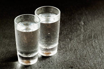 Two glasses of gin on a dark background, black and white, select