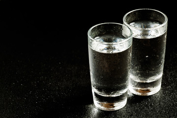Two glasses of gin on a dark background, black and white, select