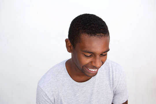 Happy young man laughing against white background