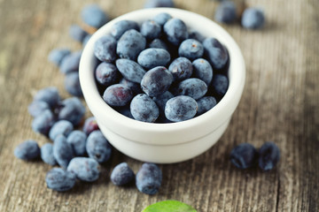 Honeysuckle berries in bowl on wooden surface