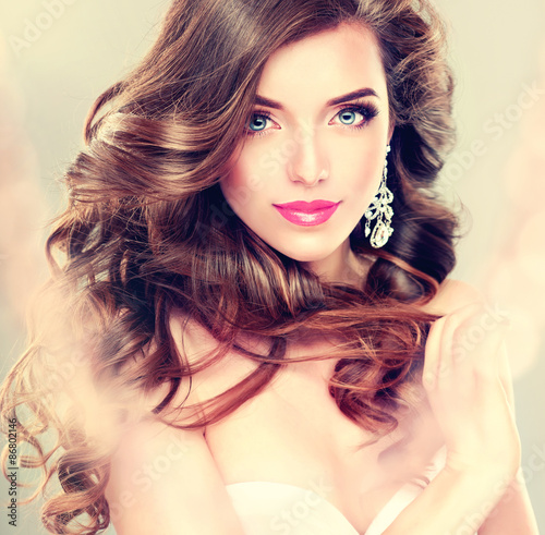 Beautiful Model Brunette With Long Curled Hair And Jewelry Earrings