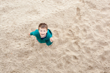 Boy on the beach looking up. Shoot from top 