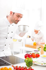 Young attractive professional chef cooking in his kitchen