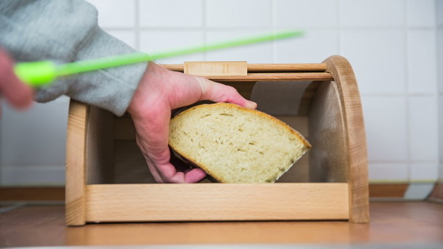 Taking bread from breadbox and slicing