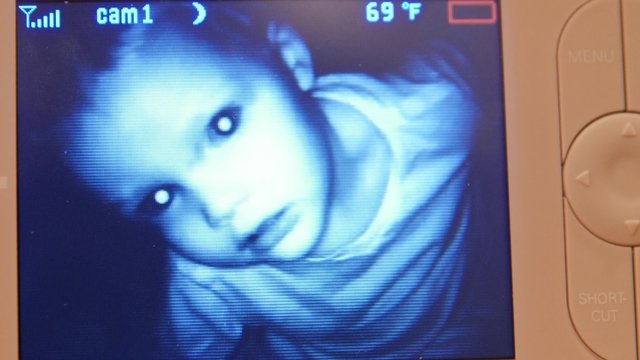 Toddler looking into a baby monitor