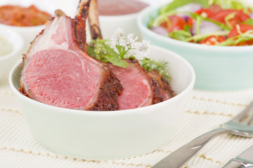 Lamb Cutlets - Spicy roasted lamb cutlets in a bowl served with salad and dips
.
