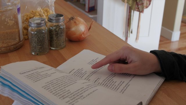 A woman with recipe book and ingredients