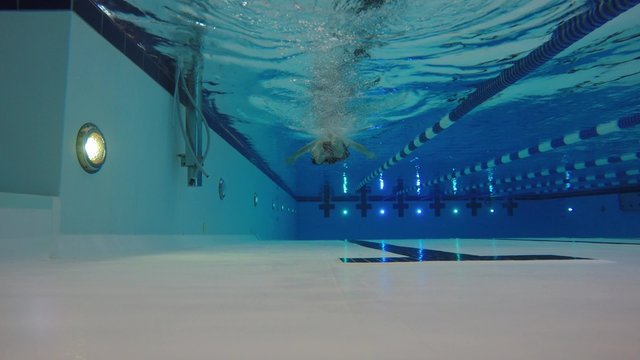 Underwater low shot of man swimming breast stroke