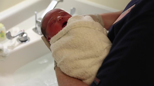newborn being bathed after birth at the hospital