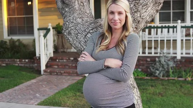 Beautiful pregnant woman standing outside