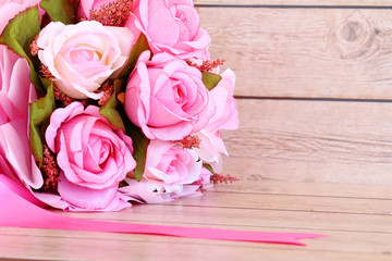 Pink roses against a wood wall