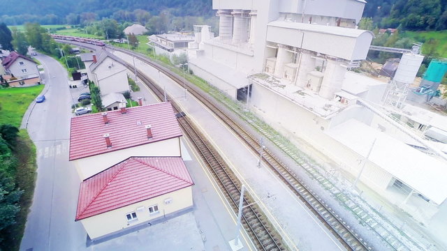 Train far away arriving at station aerial footage