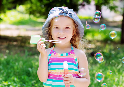 todddler happy girl blowing soap bubbles