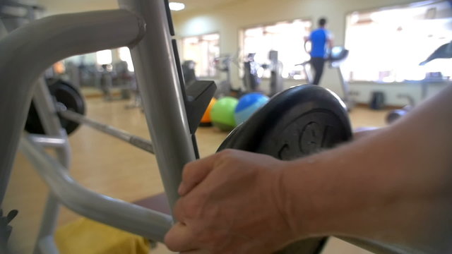Man increasing weight on barbell